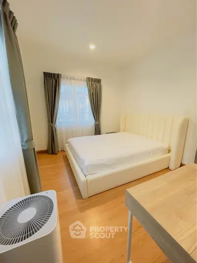 Spacious bedroom with modern decor and natural light