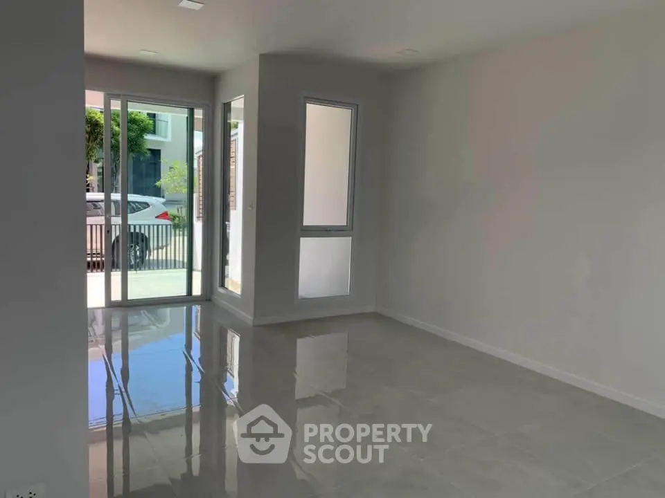 Spacious empty room with large windows and glossy tiled floors, perfect for customization.