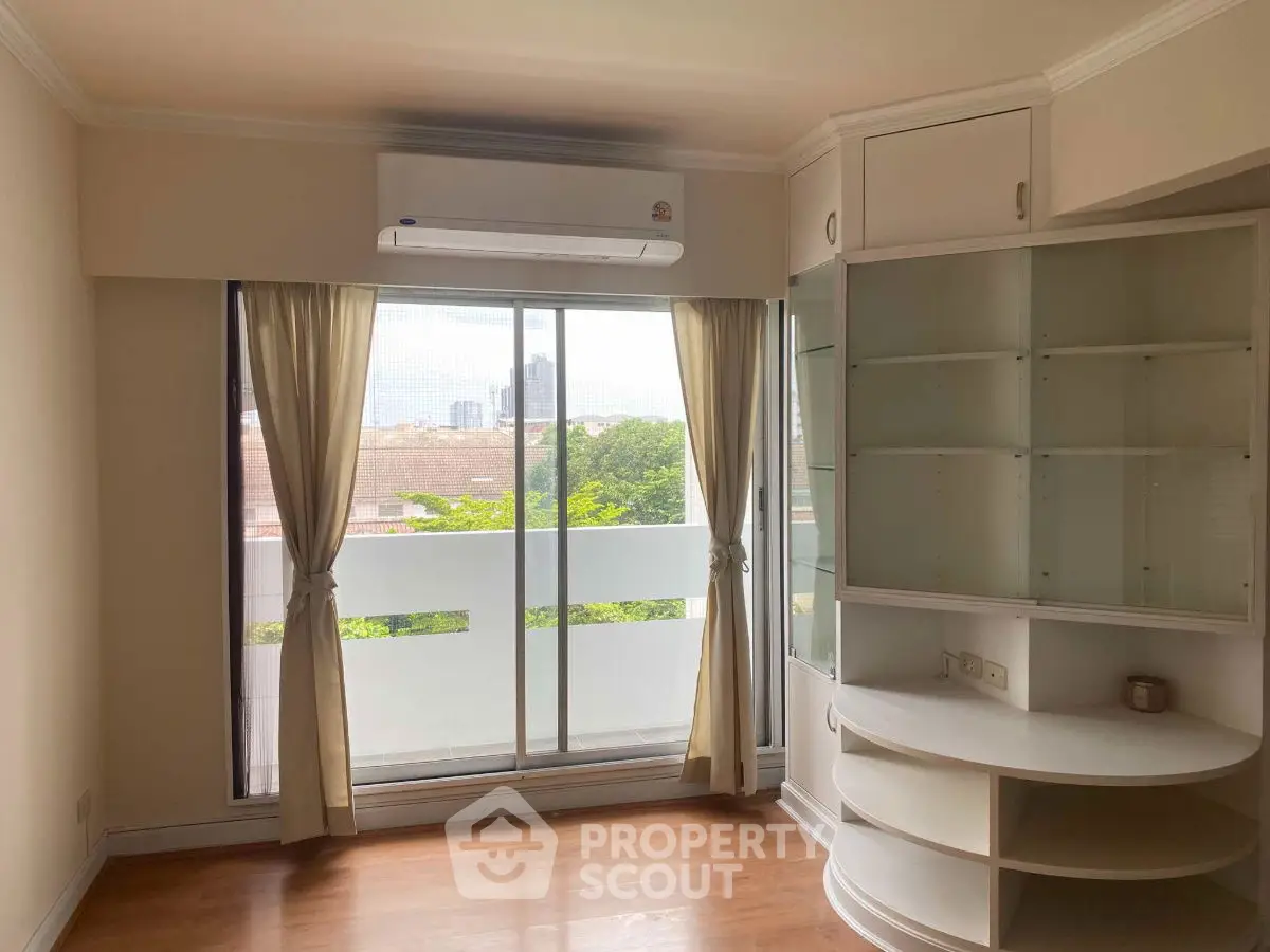 Bright room with large window and built-in shelves, ideal for a cozy living space.