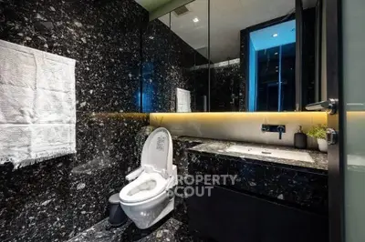 Luxurious modern bathroom with sleek black marble and elegant lighting
