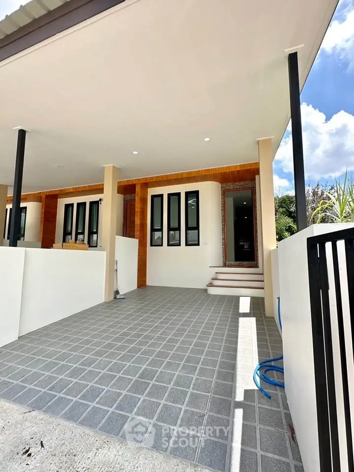 Modern house entrance with tiled patio and sleek design
