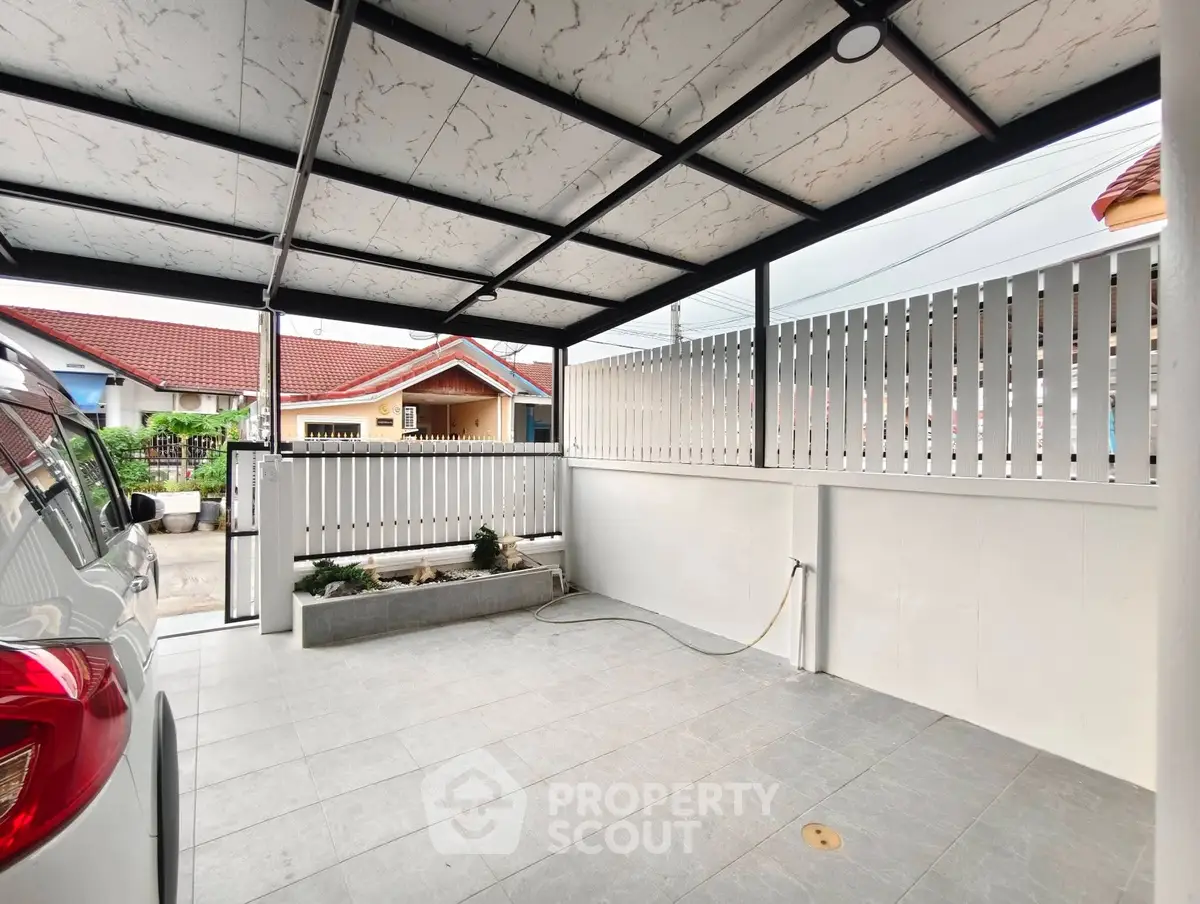 Covered carport with modern design and ample space in residential area.