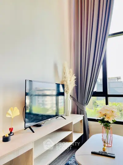 Modern living room with large window, stylish TV setup, and elegant decor.
