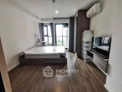 Modern bedroom with wooden flooring, large window, and air conditioning unit.