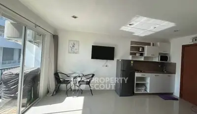 Modern studio apartment with kitchenette and balcony access, featuring sleek design and natural light.