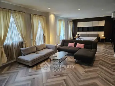 Spacious modern living room with elegant herringbone flooring and cozy seating area.