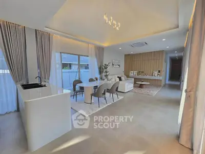 Spacious modern living room with elegant decor and open layout, featuring large windows and stylish furniture.