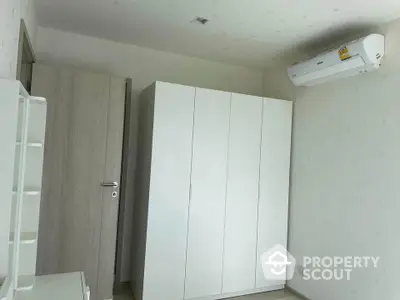 Minimalist bedroom with white wardrobe and air conditioning unit