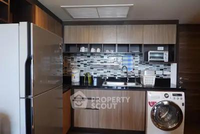 Modern kitchen with sleek appliances and stylish backsplash in a contemporary apartment.