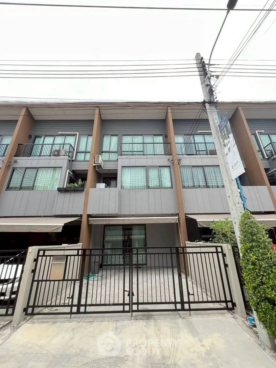Modern townhouse exterior with gated entrance and large windows