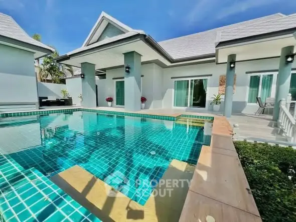 Luxurious villa with private pool and modern architecture under clear blue sky.