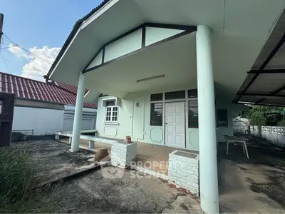 Charming single-story home with spacious front porch and unique architectural design.