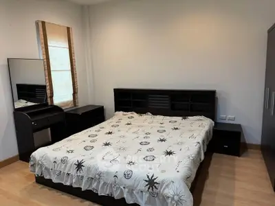 Spacious bedroom with modern furniture and natural light, perfect for relaxation and comfort.