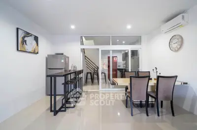 Modern dining area with sleek furniture and open kitchen layout in a stylish home.