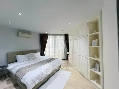 Spacious bedroom with elegant decor and large window for natural light
