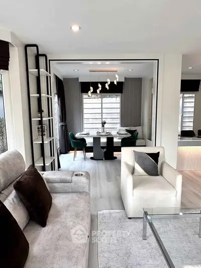 Modern living room with elegant dining area, featuring plush seating and contemporary decor.