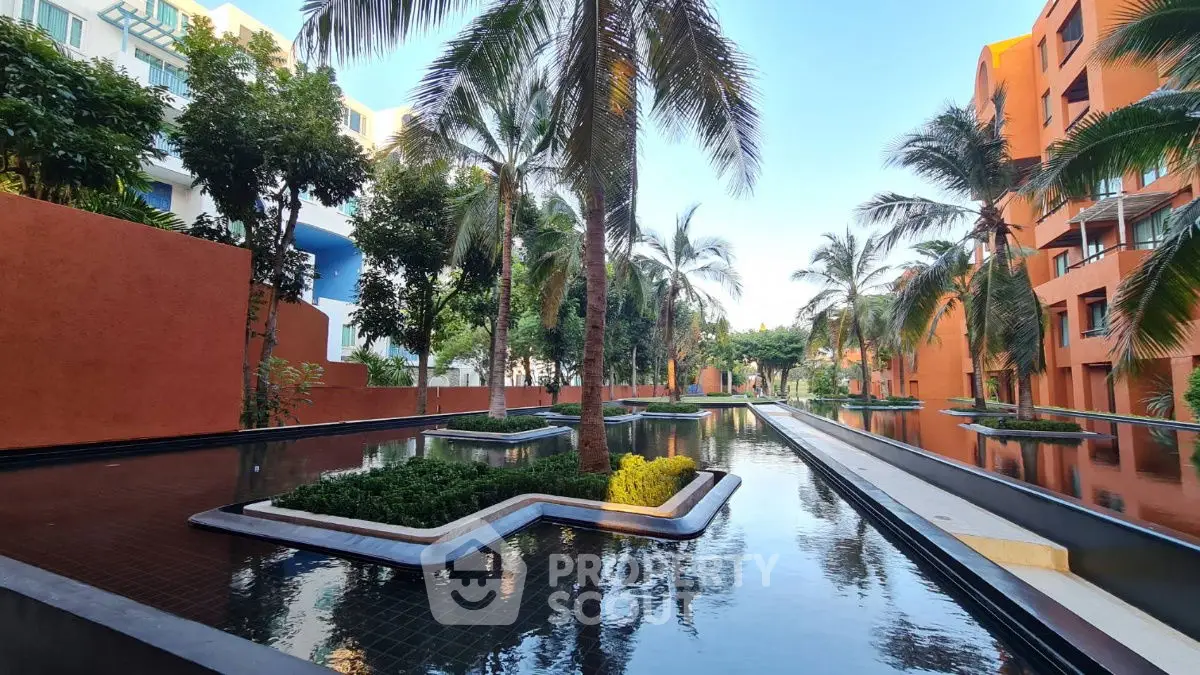Stunning tropical garden view with palm trees and water features in modern residential complex.