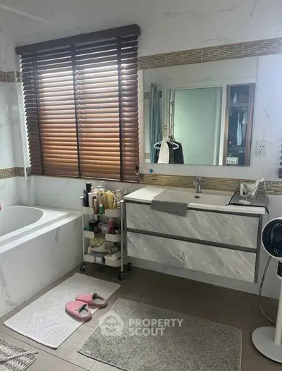 Spacious bathroom with modern fixtures and large window for natural light.
