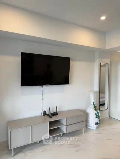 Modern living room with wall-mounted TV and sleek furniture