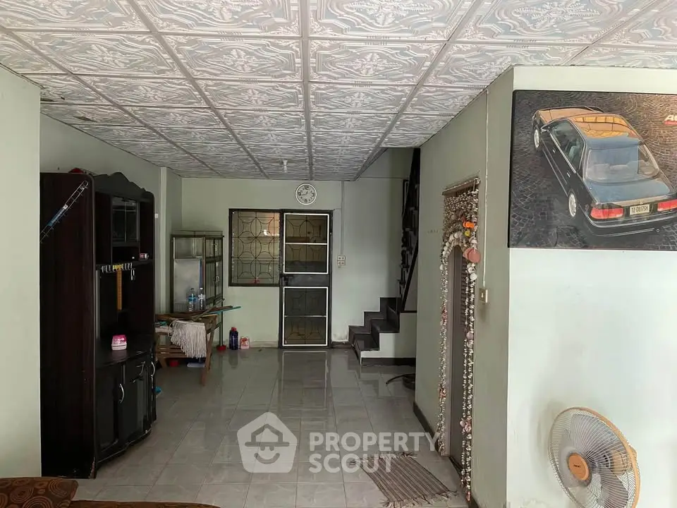 Spacious living area with unique ceiling design and staircase, ideal for family gatherings.
