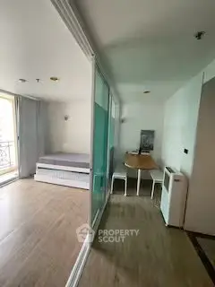Modern studio apartment with sliding glass doors and compact dining area.