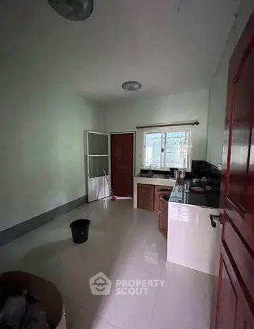 Spacious kitchen with modern cabinetry and large window for natural light.