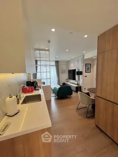 Modern open-plan kitchen and living room with stylish decor and natural light.