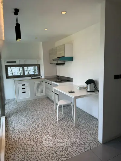 Modern kitchen with mosaic tile flooring and sleek white cabinetry