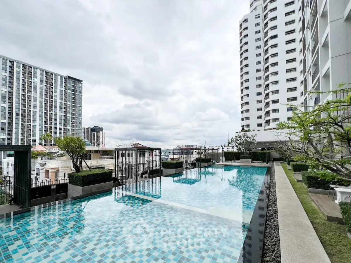Luxurious rooftop pool with stunning city views in modern high-rise building.