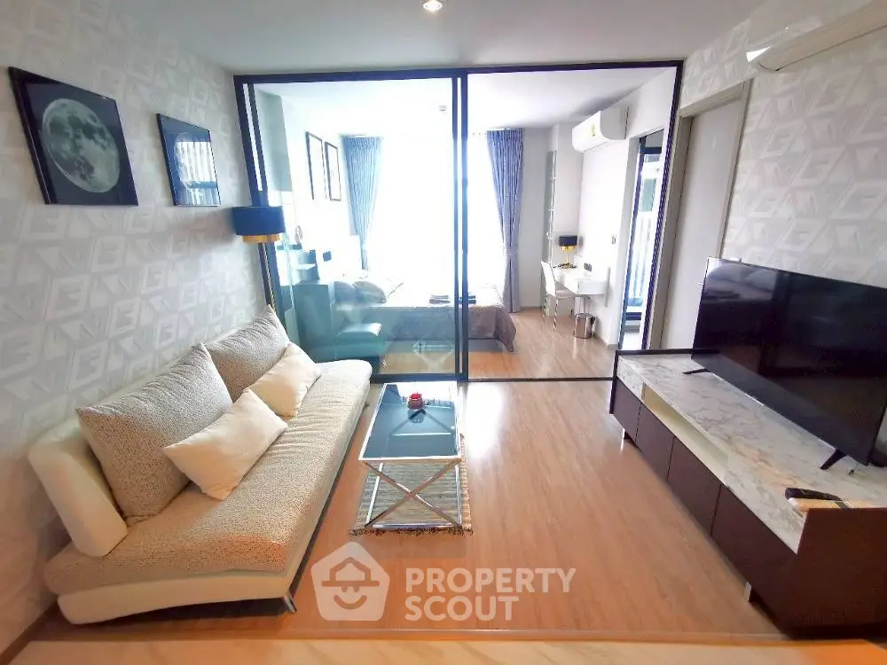 Modern living room with glass partition, stylish sofa, and sleek TV unit in a contemporary apartment.