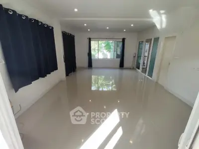 Spacious unfurnished living room with large windows and tiled flooring