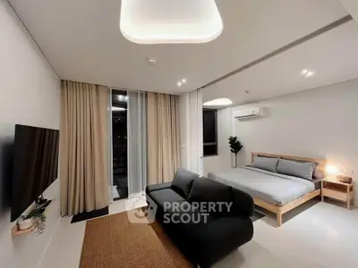 Modern studio apartment with sleek design, featuring a cozy bed, stylish sofa, and ambient lighting.