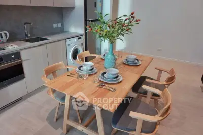 Modern kitchen with dining area featuring wooden table, chairs, and built-in appliances.