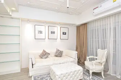 Elegant living room with white sofa, armchair, and decorative art on walls.