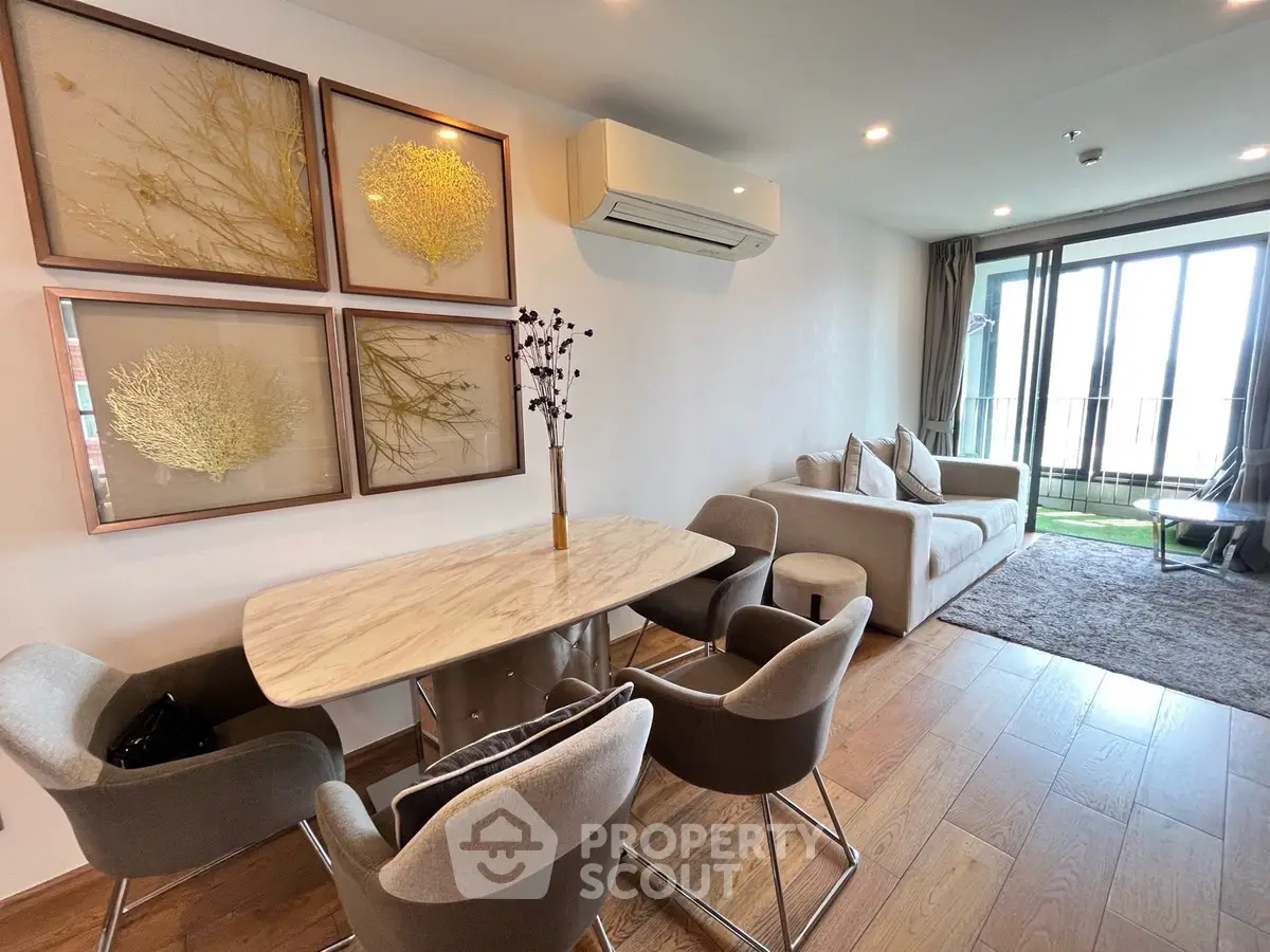 Stylish living room with modern furniture and balcony view, perfect for urban living.