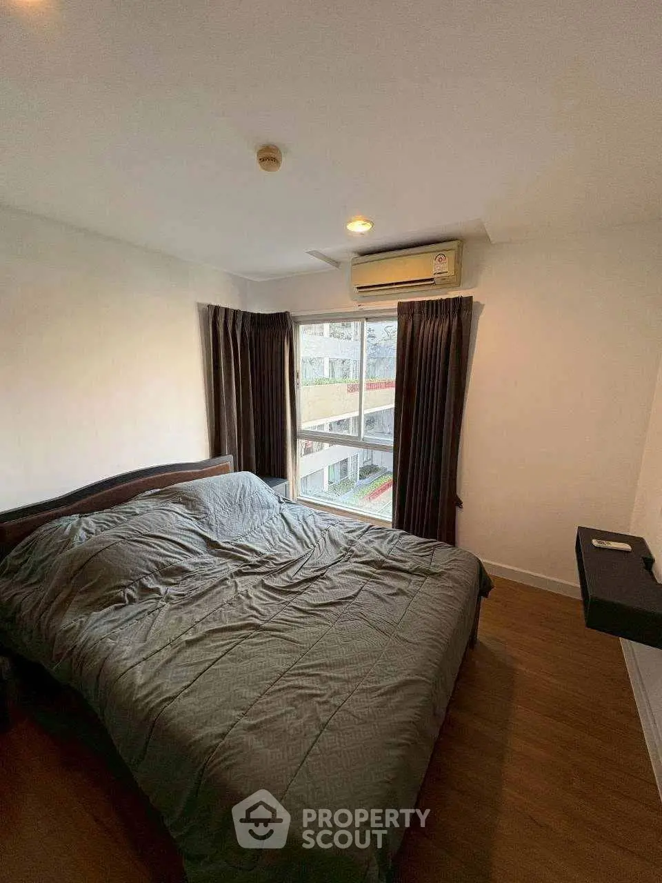 Cozy bedroom with large window and modern air conditioning unit