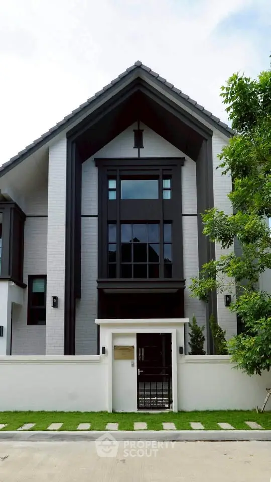 Modern two-story house with sleek design and lush greenery, perfect for contemporary living.