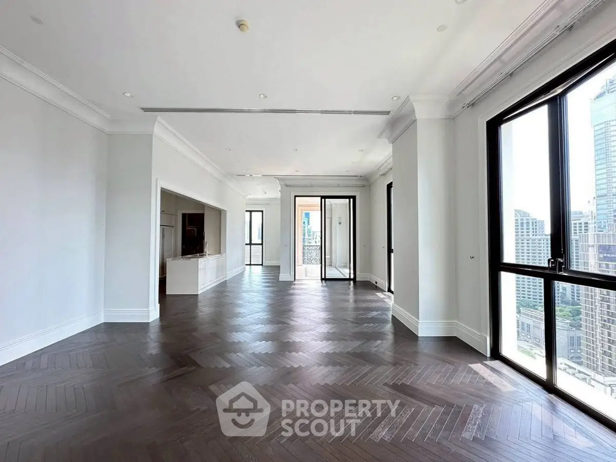Spacious modern living room with large windows and city view, featuring elegant dark wood flooring.