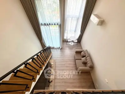 Stunning loft-style living room with high ceilings and large windows offering a panoramic city view.