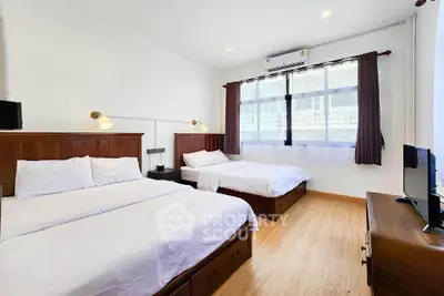 Spacious bedroom with two beds and modern decor, perfect for comfort and relaxation.