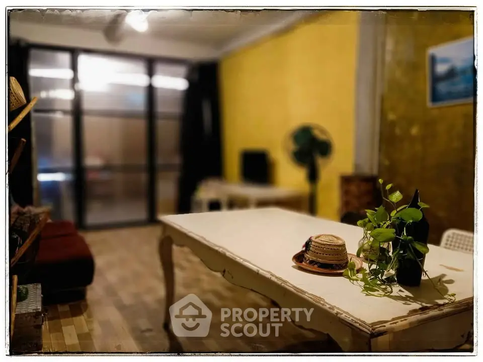Charming living room with rustic table and vibrant yellow walls, perfect for cozy gatherings.