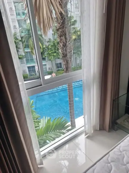 Luxurious pool view from modern apartment window, perfect for relaxation and leisure.