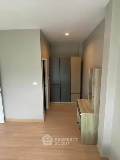 Modern minimalist bedroom with sleek storage solutions and neutral tones.