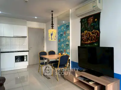 Modern living room with open kitchen, stylish decor, and cozy dining area.