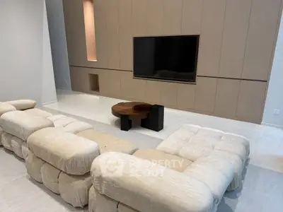 Luxurious modern living room with plush sectional sofa and sleek entertainment center.