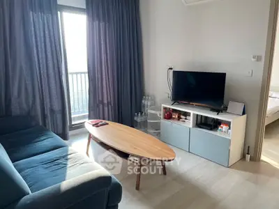 Modern living room with stylish furniture and natural light, featuring a cozy sofa and sleek TV setup.
