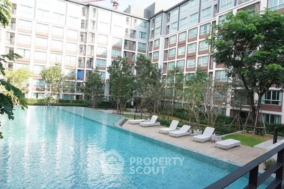 Luxurious condominium with a stunning outdoor pool and lush greenery, perfect for relaxation and leisure.