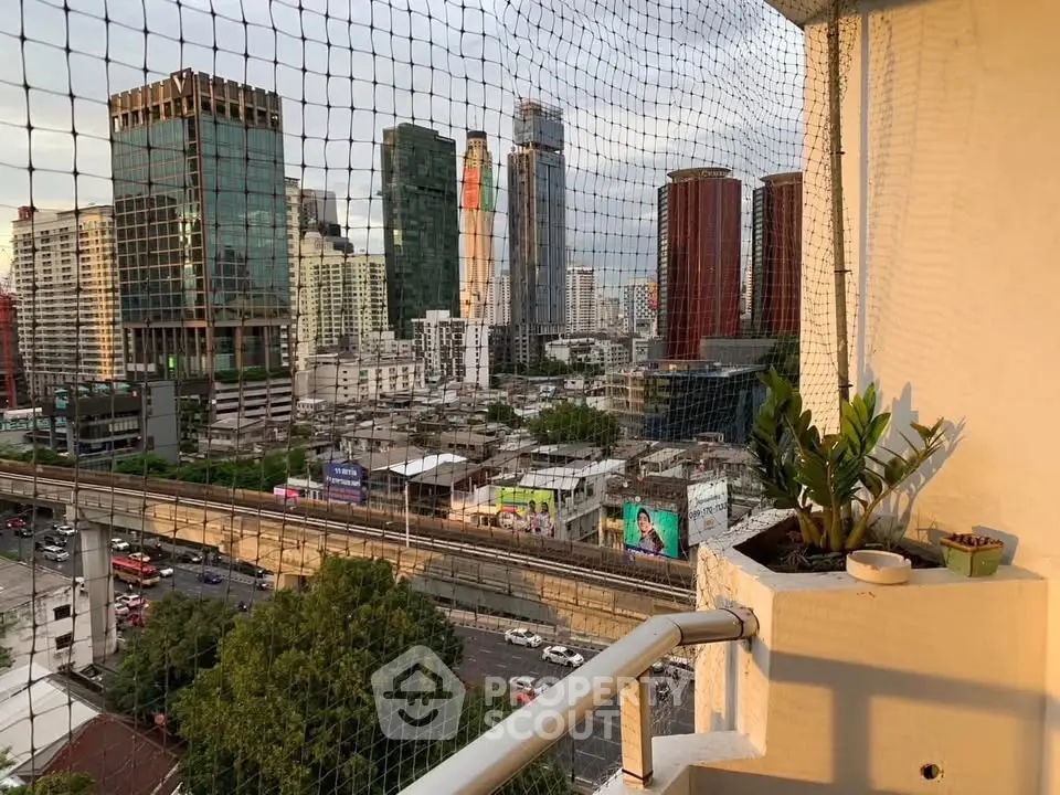 Stunning cityscape view from a high-rise balcony with safety netting, perfect for urban living.