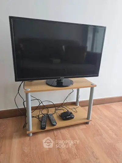 Modern living room with sleek TV setup on wooden stand, perfect for entertainment.