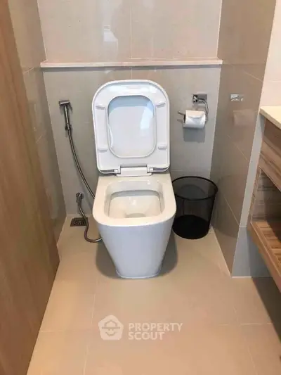 Modern bathroom with sleek toilet and neutral tiles